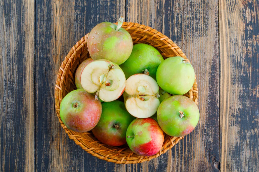 Apples in a wicker basket on a wooden background. flat lay. - Times of Dubai Indian garhwali apples in dubai a mountain delight reaches royal tables times of dubai