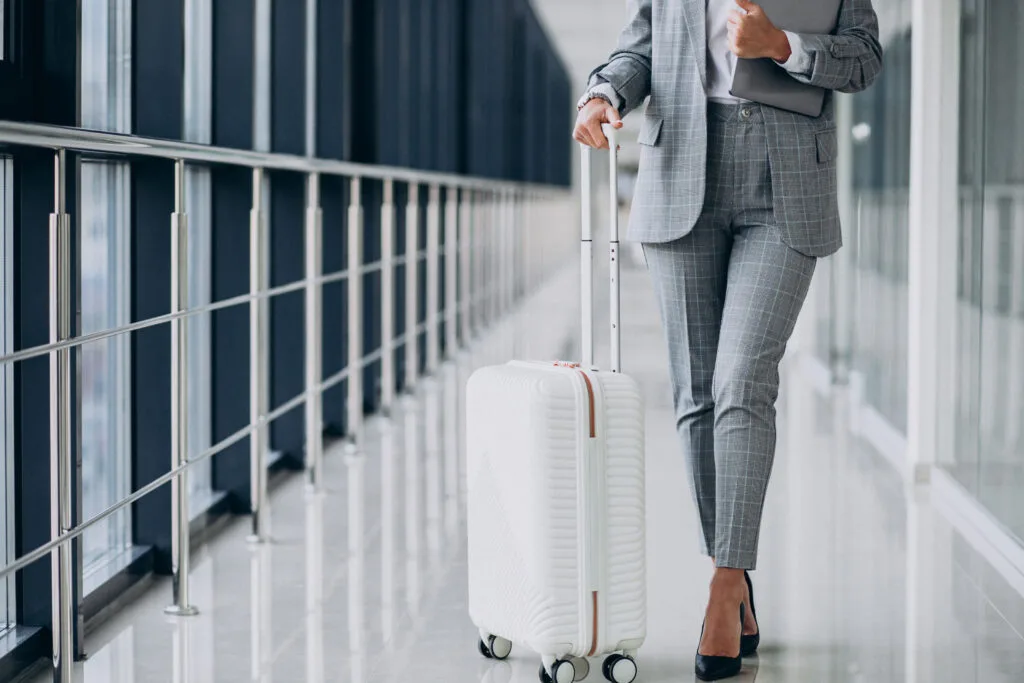 Business woman with travel luggage in airport, holding laptop - Times of Dubai Uae airline lost luggage issues legal steps every traveler should know times of dubai