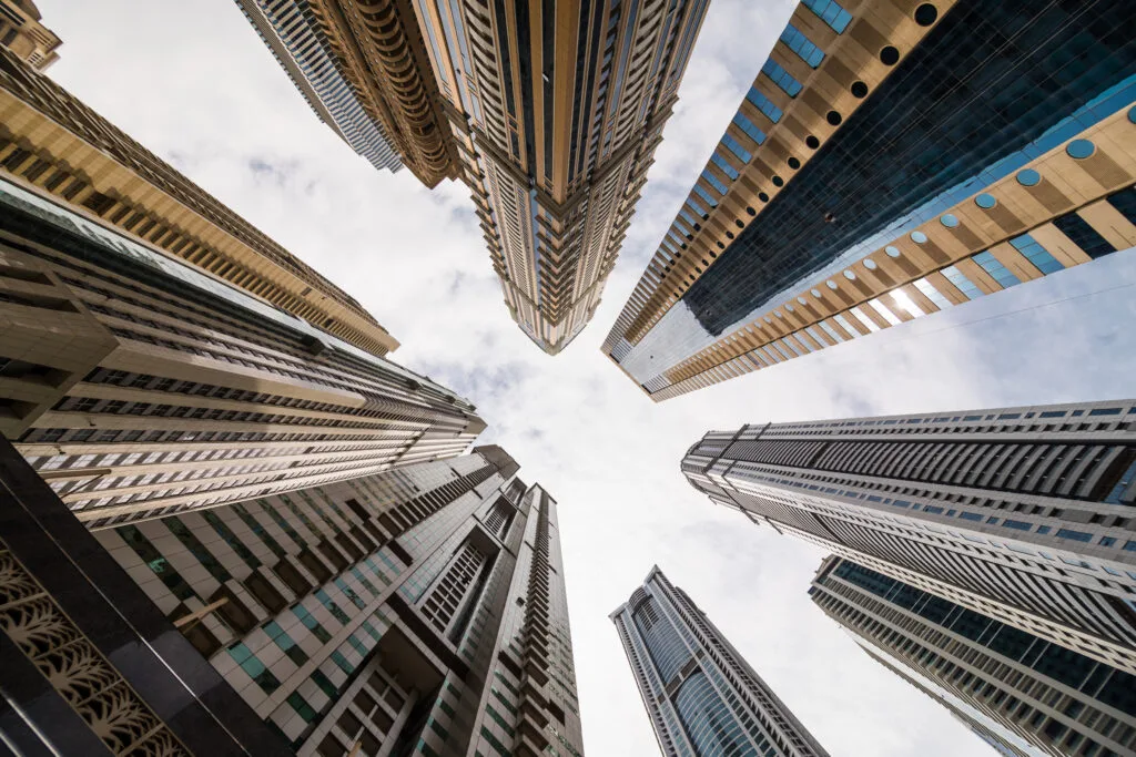 Dramatic perspective with low angle view of skyscrapers looking up to the sky, Dubai. - Times of Dubai Indian investment rules in uae property why credit cards wont work for down payments times of dubai
