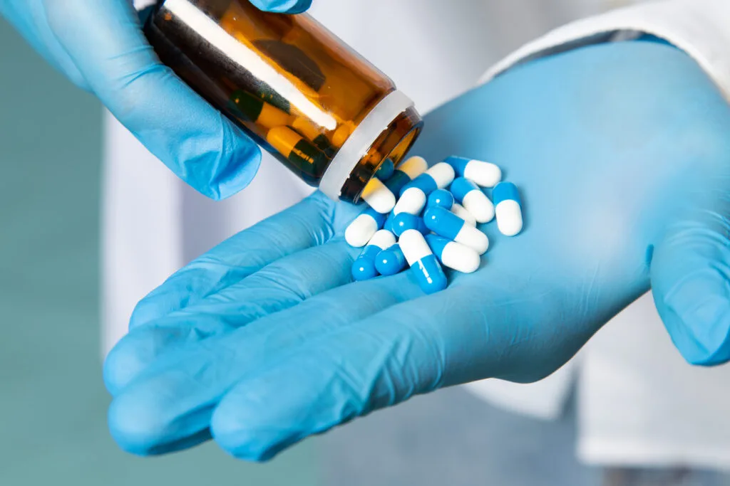 front-view-young-man-white-shirt-blue-gloves-taking-pills-blue-space - Times of Dubai Uae extradites two high profile drug criminals to france and belgium times of dubai