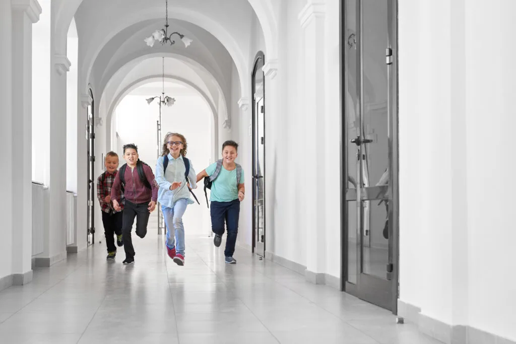 Happy classmates running in school after lessons. - Times of Dubai Uae school calendar 2025 longer winter break new mid term holidays times of dubai