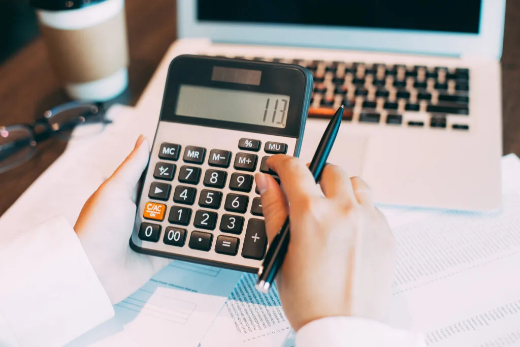 Female accountant using calculator at laptop - Times of Dubai Saudi arabia vat refund times of dubai