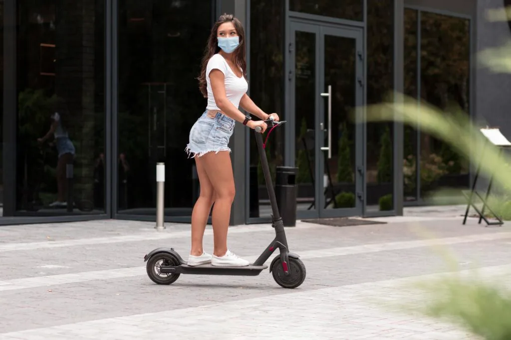 side-view-woman-with-mask-riding-electric-scooter - Times of Dubai Ajman e scooter ban a tough call but safety must come first said families times of dubai