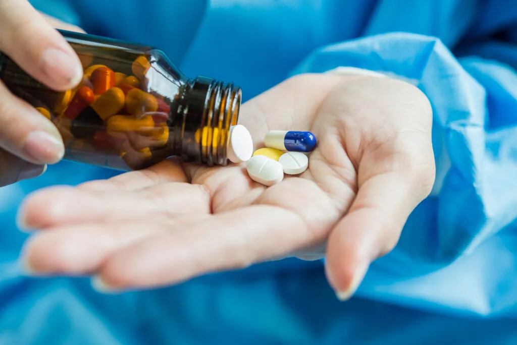 Woman's hand pours the medicine pills out of the bottle - Times of Dubai Uae extradites two high profile drug criminals to france and belgium times of dubai